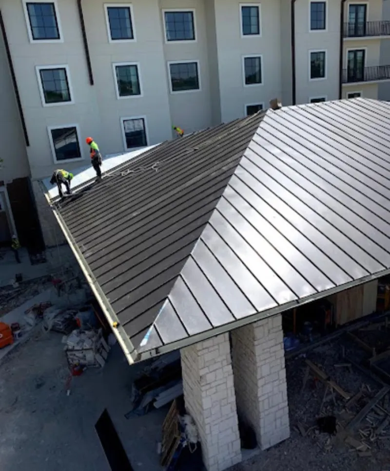 Crew installing standing seam metal roof panels on a commercial project in West Jordan
